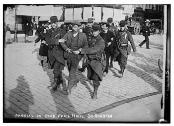 Taking Someone From Police Custody is a Crime Under Penal Code 405(a) (PC) 1 A vintage image of officers walking a man in handcuffs away in a large group.