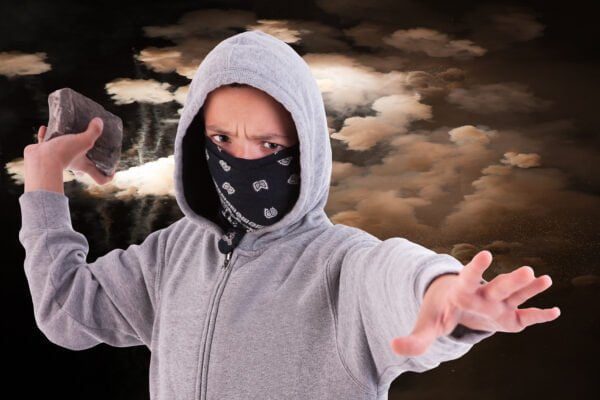 Is Throwing Something at a Car Illegal? Yes, Throughout Vista and the Rest of California 1 Teenager holding a rock as though he is ready to throw it at a vehicle.