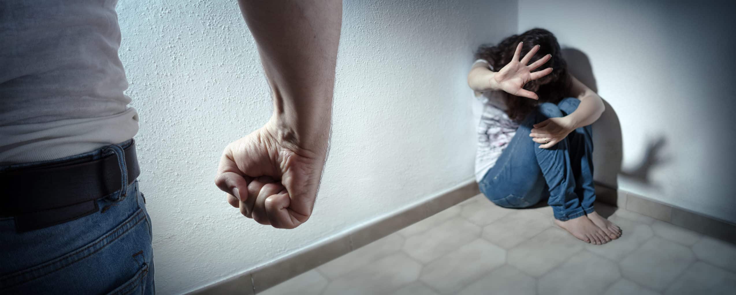 Abogado de violencia doméstica en Vista 5 hombre haciendo puño con mujer asustada en la esquina