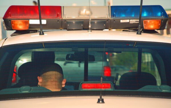 What Happens to Your Stuff When You go to Prison? 1 Man in police car used to illustrate what happens to your property when you go to jail.