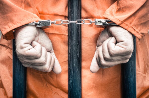 Resisting an Executive Officer in the Performance of Their Duties 1 A person in a jumpsuit with handcuffs who could be being charged with resisting an arresting officer